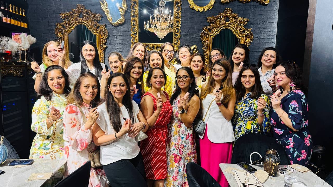 Guests at an Earthy Elegance ladies' event DIY beauty station holding their own lipstick creations